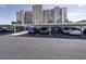 View of parking lot with covered parking spaces with The International building in the background at 7600 Sun Island S Dr # 603, South Pasadena, FL 33707