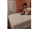 Bedroom with orange walls, decorative painting, and charming white bed at 7608 Chenkin, Zephyrhills, FL 33540