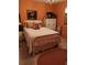 Bedroom with orange walls, decorative painting, and charming white bed at 7608 Chenkin, Zephyrhills, FL 33540