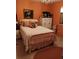 Bedroom with orange walls, decorative painting, and charming white bed at 7608 Chenkin, Zephyrhills, FL 33540