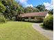 Ranch style home featuring mature trees and landscaping, long driveway and neutral color palette at 7608 Chenkin, Zephyrhills, FL 33540