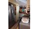 Galley kitchen with stainless steel refrigerator and white cabinetry at 7608 Chenkin, Zephyrhills, FL 33540