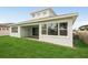 Home backyard featuring lush green grass, a covered patio, and large windows providing plenty of natural light at 8316 Golden Beach Ct, Parrish, FL 34219