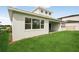 Home backyard featuring lush green grass, a covered patio, and large windows providing plenty of natural light at 8316 Golden Beach Ct, Parrish, FL 34219