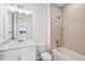 Tiled bathroom with a shower-tub combination, white toilet, sink, cabinets and an open door offering natural light at 8316 Golden Beach Ct, Parrish, FL 34219