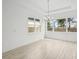 Bright dining area with wood-look tile, modern chandelier, and large windows at 8316 Golden Beach Ct, Parrish, FL 34219