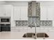 A well-appointed kitchen features a stainless steel sink, quartz countertops, and a stylish mosaic backsplash at 8316 Golden Beach Ct, Parrish, FL 34219