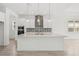 Bright, open kitchen with an island, stylish backsplash, stainless steel appliances, and modern pendant lighting at 8316 Golden Beach Ct, Parrish, FL 34219