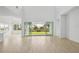 Bright and airy living room with wood floors, white walls, and view of backyard through sliding glass doors at 8316 Golden Beach Ct, Parrish, FL 34219
