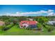 Aerial view of home featuring a red tile roof, screened pool, and lush green landscaping with mature trees at 8822 Misty Creek Dr, Sarasota, FL 34241