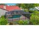 Aerial view of a home with a screened pool, red tile roof, and meticulously landscaped yard at 8822 Misty Creek Dr, Sarasota, FL 34241
