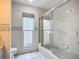 Cozy bathroom featuring a glass-enclosed bathtub shower and window for natural light at 8822 Misty Creek Dr, Sarasota, FL 34241