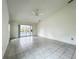 Open floor plan living room with tile flooring and sliding glass doors leading to a screened-in pool area at 8822 Misty Creek Dr, Sarasota, FL 34241