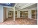 Expansive covered patio with brick flooring, ceiling fan, and multiple sliding glass doors to bring the outdoors in at 8822 Misty Creek Dr, Sarasota, FL 34241