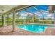 Enjoy a sparkling screened-in pool, perfect for relaxation, with lush landscaping and a golf course view at 8822 Misty Creek Dr, Sarasota, FL 34241