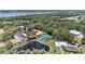 Aerial view showcasing tennis court, pond, pool, and lush greenery around these single-story homes at 9521 86Th Ave # 9521, Seminole, FL 33777