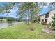 Backyard featuring well-maintained lawn and serene lake view adjacent to a multi-story residential home at 9521 86Th Ave # 9521, Seminole, FL 33777