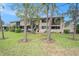 Backyard with trees and green lawn, overlooking a patio area of a multi-story residential home at 9521 86Th Ave # 9521, Seminole, FL 33777