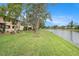 Backyard view features a lush lawn and serene lake view of a multi-story residential home at 9521 86Th Ave # 9521, Seminole, FL 33777
