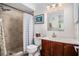 Bathroom with a tiled shower, neutral walls, and a dark wood vanity with a decorative mirror at 9521 86Th Ave # 9521, Seminole, FL 33777
