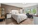 Bright bedroom featuring a queen bed, wood floors, and a well-lit desk area with a view at 9521 86Th Ave # 9521, Seminole, FL 33777
