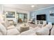 Light-filled living room with wood floors, neutral sofa, and sliding doors to a screened patio at 9521 86Th Ave # 9521, Seminole, FL 33777