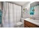 Cozy bathroom features a wood vanity, ceramic tile floor, and a shower with a patterned curtain at 960 Virginia St # 202, Dunedin, FL 34698