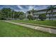 A well-maintained exterior building is enhanced by verdant grass, swaying palms, and convenient covered parking at 960 Virginia St # 202, Dunedin, FL 34698