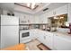 Modern kitchen with white cabinets, tile backsplash, and view to the living area at 960 Virginia St # 202, Dunedin, FL 34698