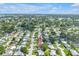 Drone shot of neighborhood featuring many tree lined streets and view of nearby lakes at 9892 111Th St, Seminole, FL 33772
