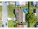 Overhead aerial view of the backyard including a pool, outdoor seating area, driveway, and surrounding greenery at 9892 111Th St, Seminole, FL 33772