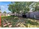 Spacious backyard with lush lawn, mature tree, a black grill, and a fence offering privacy at 9892 111Th St, Seminole, FL 33772