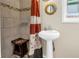 Bathroom including a pedestal sink, framed mirror, and shower with tiled walls and colorful shower curtain at 9892 111Th St, Seminole, FL 33772