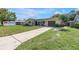Charming single-story home with a well-maintained lawn and a long driveway leading to the garage at 9892 111Th St, Seminole, FL 33772