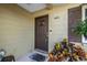 A welcoming front door with sidelight, address numbers and colorful foliage in front at 9892 111Th St, Seminole, FL 33772