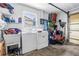 Functional laundry room space with washer, dryer, utility sink, shelving, and garage access at 9892 111Th St, Seminole, FL 33772
