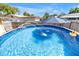 A backyard pool with a fountain, ladder, and a yellow floatie, offering a fun and refreshing escape at 9892 111Th St, Seminole, FL 33772