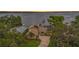 Waterfront home with palm trees, mature landscaping, and a private dock offers stunning views of the lake at 115 Lake Shore E Dr, Palm Harbor, FL 34684