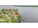 Stunning aerial view of a waterfront property surrounded by lush greenery and tranquil lake waters at 115 Lake Shore E Dr, Palm Harbor, FL 34684