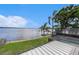 Backyard with screened-in pool, dock and a waterfront view at 115 Lake Shore E Dr, Palm Harbor, FL 34684