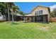 Beautifully landscaped backyard with a screened in pool and outdoor seating at 115 Lake Shore E Dr, Palm Harbor, FL 34684
