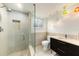 Modern bathroom with glass-enclosed shower, stylish vanity, and vibrant pendant lighting at 115 Lake Shore E Dr, Palm Harbor, FL 34684