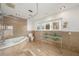 Elegant bathroom featuring a granite surround tub and double vanity with stylish glass countertops at 115 Lake Shore E Dr, Palm Harbor, FL 34684