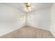 Clean bedroom with neutral carpet, a ceiling fan, and two windows for ample natural light at 115 Lake Shore E Dr, Palm Harbor, FL 34684