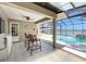 Outdoor living area with a bar, seating and view of the pool and lake at 115 Lake Shore E Dr, Palm Harbor, FL 34684
