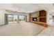 Spacious living room with a stone fireplace, built-in shelves, and sliding doors to the outdoors at 115 Lake Shore E Dr, Palm Harbor, FL 34684