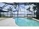 Screened-in pool with rock detail and view of the lake at 115 Lake Shore E Dr, Palm Harbor, FL 34684