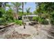 Lush backyard with a stone picnic table set, mature trees, and white rock ground cover, perfect for outdoor living at 1151 Lancer Ln, Tarpon Springs, FL 34689