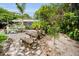 Backyard features a decorative stone picnic table set, white rock ground cover, and pathway at 1151 Lancer Ln, Tarpon Springs, FL 34689