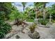 Secluded backyard with tropical plants, shrubbery and rock features in this outdoor space at 1151 Lancer Ln, Tarpon Springs, FL 34689